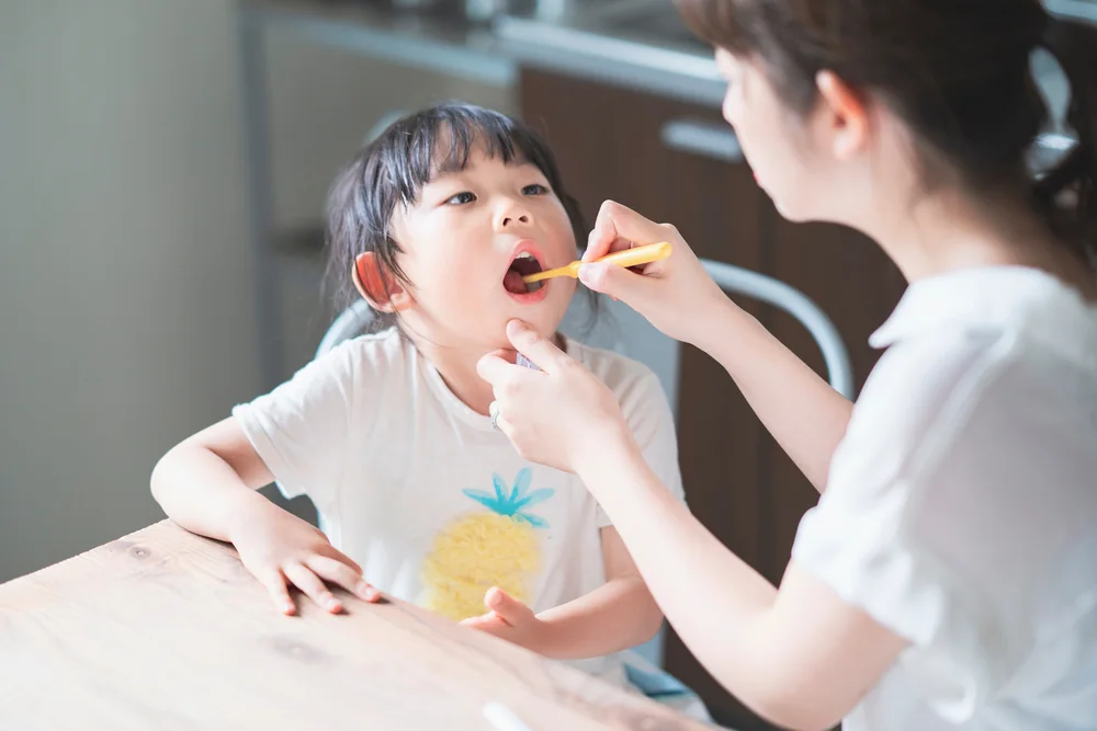 保護者が子どもの歯を仕上げみがきしている様子